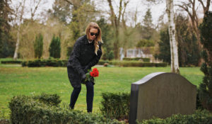 お墓に花を添える女性